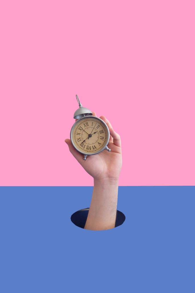 A hand holding a clock